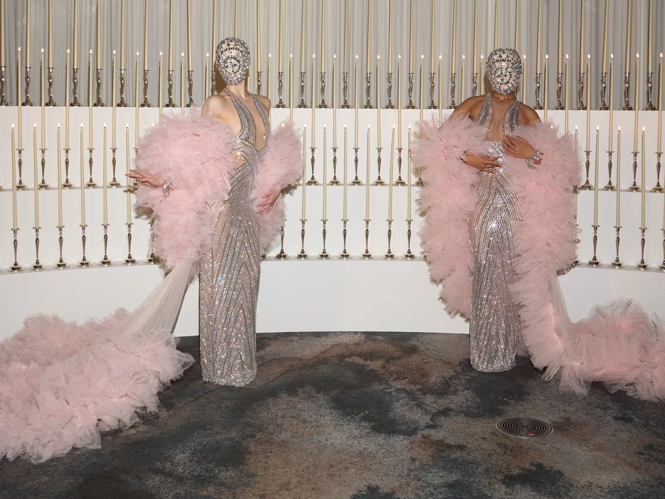 Models in couture gowns before a candle wall at the Wedded World Showcase