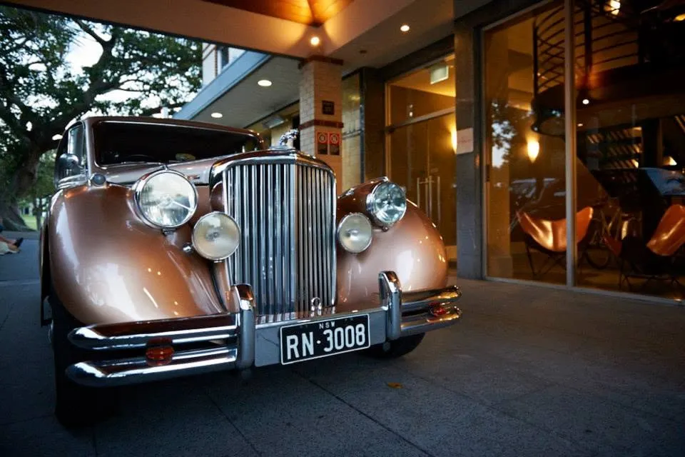 A vintage wedding car waiting outside the venue