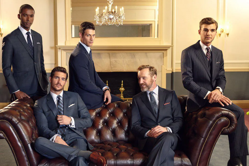 Five men in tailored suiting in a panelled lounge, styled for Wedded World: Him