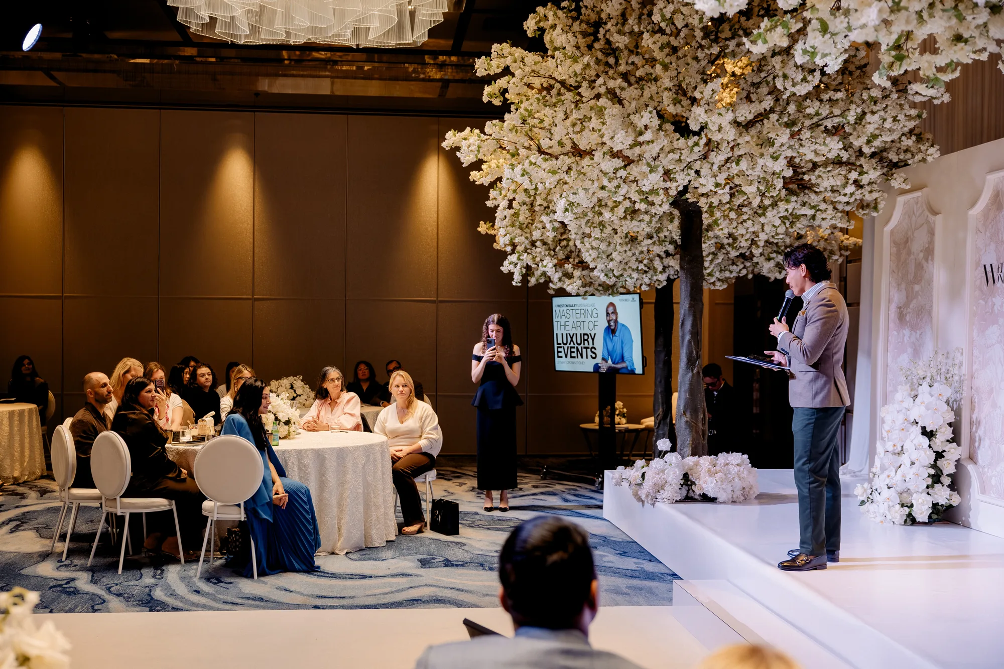 A speaker presenting to seated delegates at the Wedded Wonderland Summit