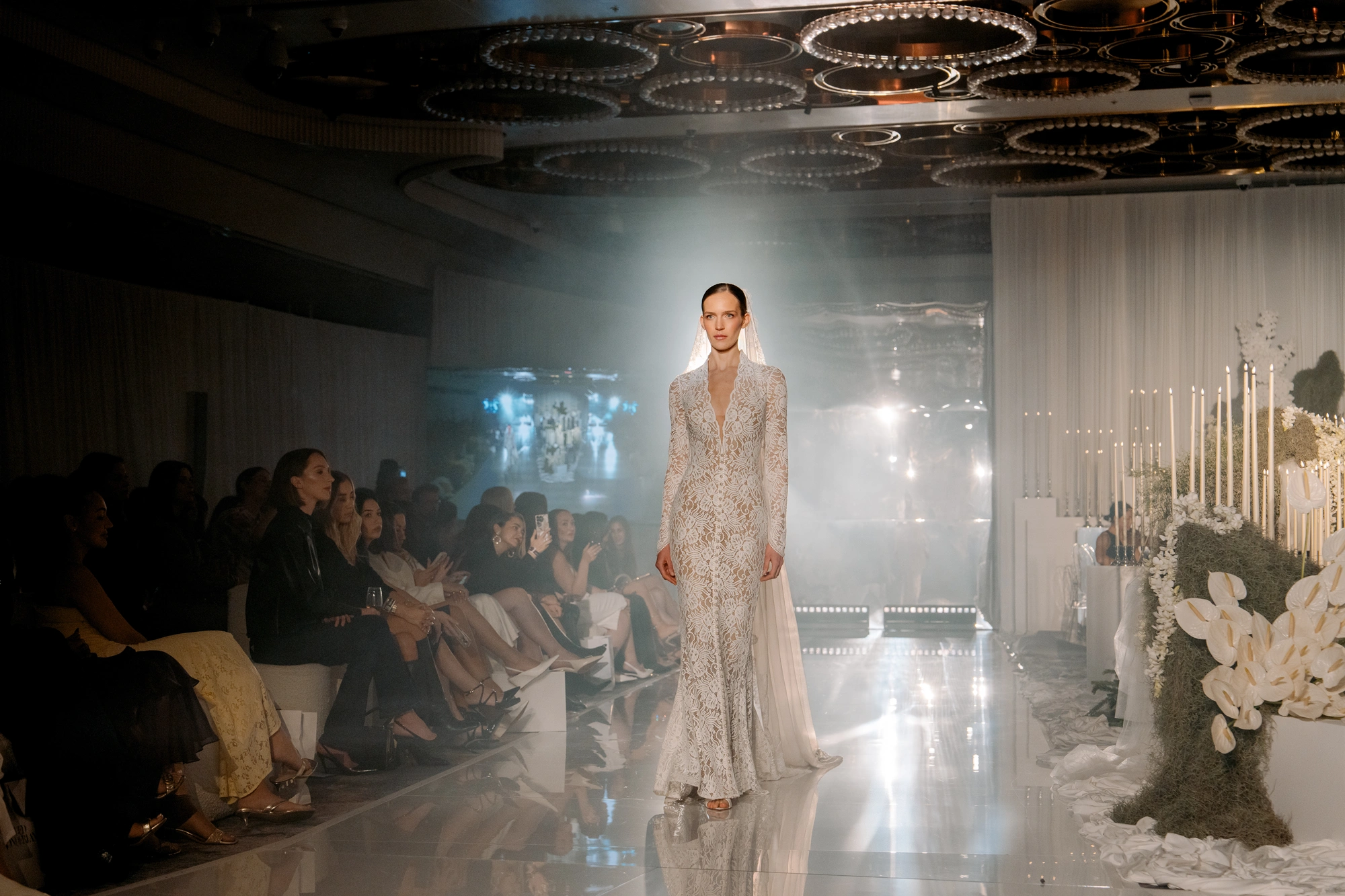 A model in a lace bridal gown on the couture runway at Wedded World