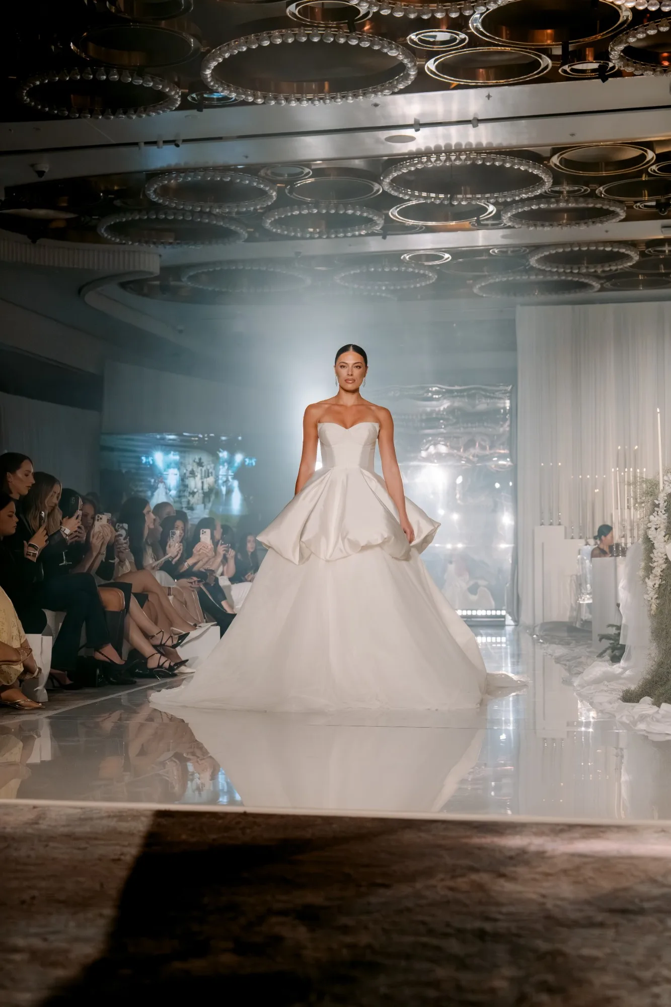 A bride in a sculpted ball gown on the runway