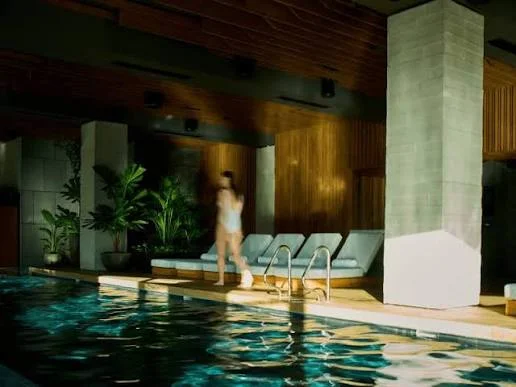 The indoor pool and loungers at 1 Hotel Melbourne